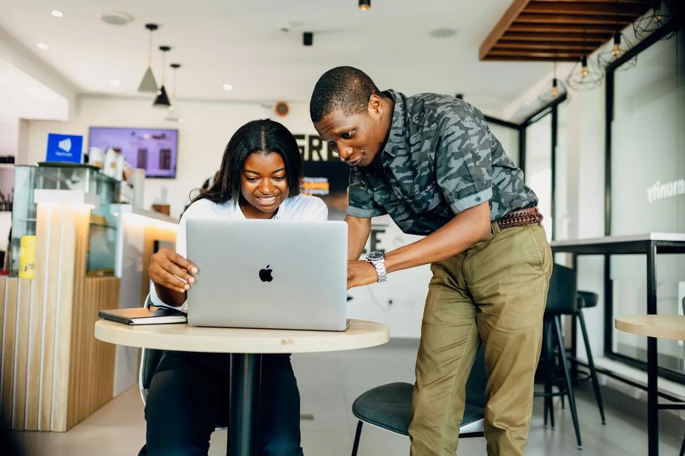 A teammate guiding a colleague through setup on a laptop