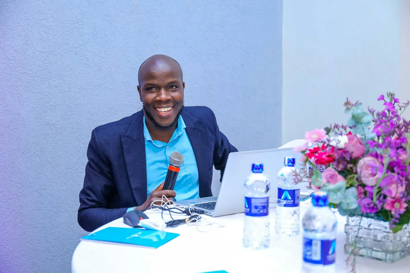 Team member smiling at his desk with a laptop